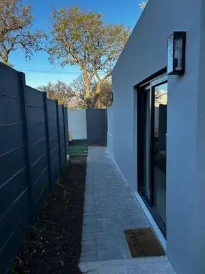 a walkway next to a white building with a fence at Alicante in Worcester