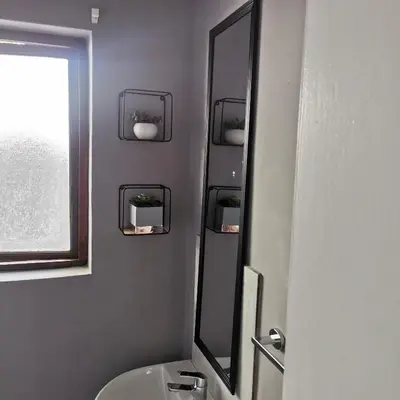a bathroom with a mirror and a sink and a window at Sune's self catering 2 in Worcester