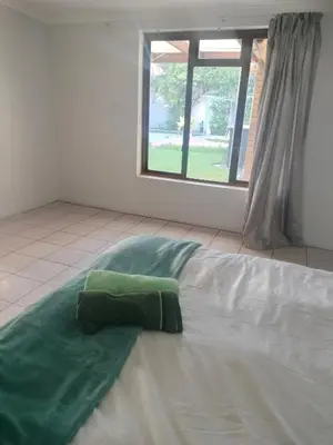 a bed with a green pillow on top of it at Near Grandwest in Thornton