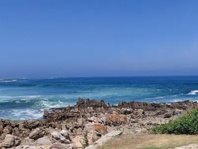 a group of people on a rocky beach with the ocean at Nerf-af Cottage at Onrus, Hermanus in Hermanus