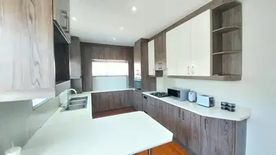 a kitchen with wooden cabinets and a white counter top at B3 bnb House