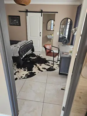 a bedroom with a bed and a desk and a mirror at Cape Town Glam in Welgemoed