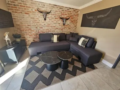 a living room with a couch and a table at Cape Town Glam in Welgemoed