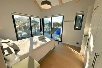 a bedroom with a bed and a large window at Modern 4BDR Flaming Bay in Hermanus in Hermanus