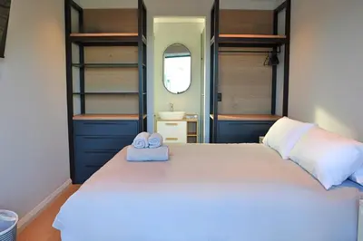 a bedroom with a bed with two towels on it at Modern 4BDR Flaming Bay in Hermanus in Hermanus