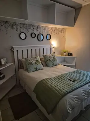 a bedroom with a large bed with four mirrors on the wall at Suné's Self Catering 1 in Worcester