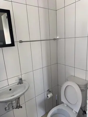 a white bathroom with a toilet and a sink at Legacy lodge in Goodwood