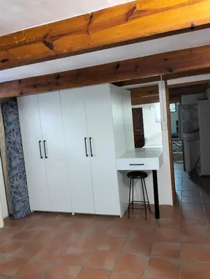 a kitchen with white cabinets and a desk at Pet Friendly Sandbaai in Hermanus