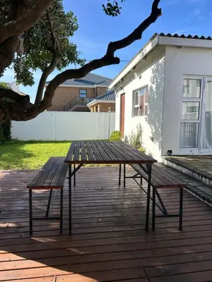 a picnic table and two benches on a patio at Protea Escape - Apartment in Hermanus