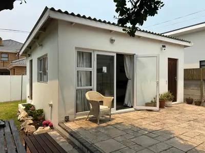 a chair sitting in front of a house at Protea Escape - Apartment in Hermanus