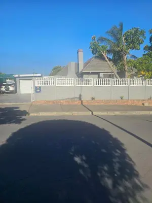 a street with a white fence and a house at Ludinz Self Catering Guest House