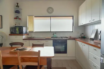 a kitchen with a table and a table and a window at Leah's View in Pringle Bay