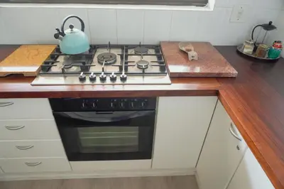 a kitchen with a stove with a tea kettle on it at Leah's View in Pringle Bay
