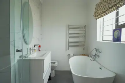 a bathroom with a tub and a sink and a toilet at Leah's View in Pringle Bay