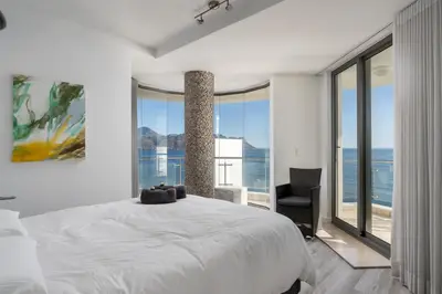 a bedroom with a white bed and a large window at Main Hibernian Penthouse in Strand
