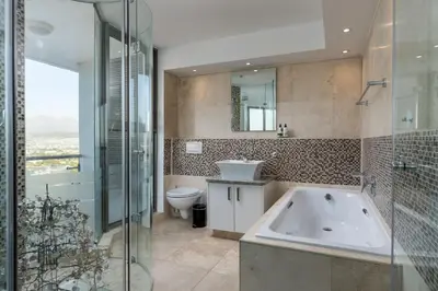 a bathroom with a tub and a sink and a toilet at Main Hibernian Penthouse in Strand