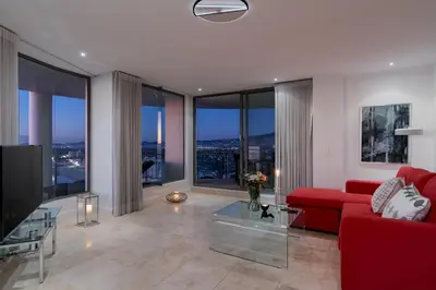 a living room with a red couch and large windows at Main Hibernian Penthouse in Strand