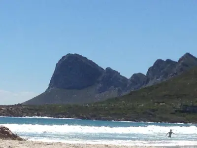 a person on a beach with mountains in the background at Pringle Beach House in Pringle Bay