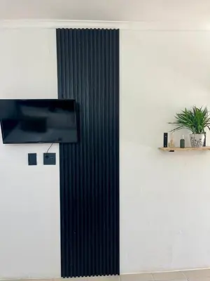 a wall with a flat screen tv on a wall at Angel's Cottage in Paarl