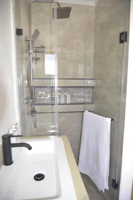 a bathroom with a sink and a shower with a towel at Misasa on Orchard in Cape Town