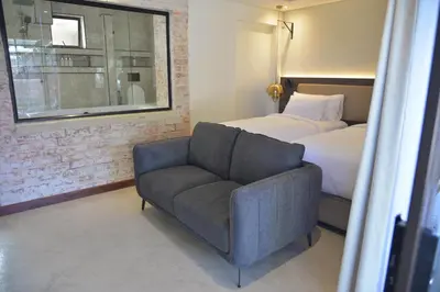 a bedroom with a bed and a chair and a couch at Misasa on Orchard in Cape Town