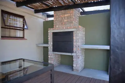 a room with a brick fireplace with a flat screen tv at Misasa on Orchard in Cape Town