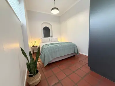 a bedroom with a bed and a potted plant at Die Stal in Wellington