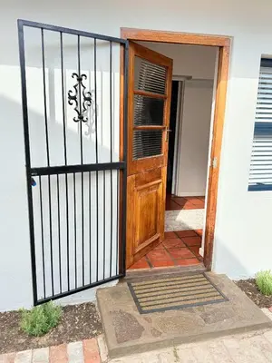 a wooden door with a gate in front of a house at Die Stal in Wellington