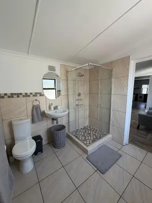 a bathroom with a shower and a toilet and a sink at Fijnbos in Strand