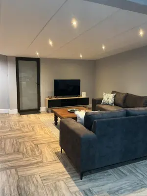 a living room with two couches and a flat screen tv at Fijnbos in Strand