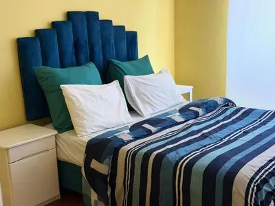 a bedroom with a bed with a blue headboard at Home of peace self catering accommodation
