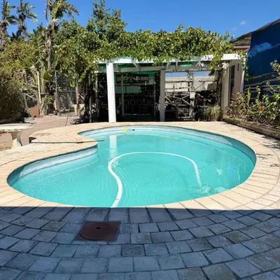 a small swimming pool in a yard with a building at Home of peace self catering accommodation