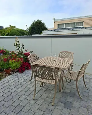 a table and chairs on a patio with flowers at Bird's Landing in Hermanus