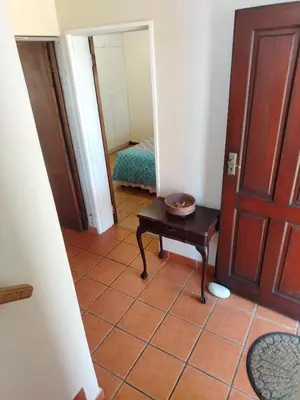 a hallway with a door and a table in a room at Starfish - The rockpool house in Bettyʼs Bay