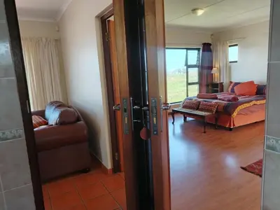 a room with a living room with a couch and a door at Starfish - The rockpool house in Bettyʼs Bay