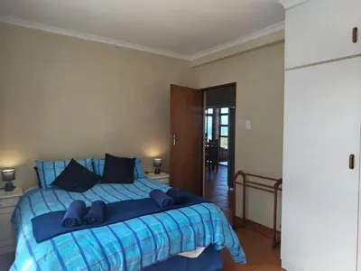 a bedroom with a blue bed with blue sheets at Starfish - The rockpool house in Bettyʼs Bay