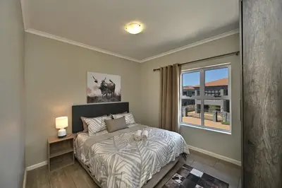 a bedroom with a bed and a window at The lodge in Cape Town