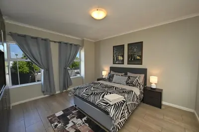 a bedroom with a zebra print bed and a window at The lodge in Cape Town