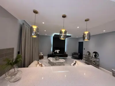 a large living room with a table and a living room at Canal Walk Luxury 2 Bedroom Apartments in Cape Town
