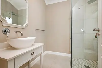 a bathroom with a sink and a shower at L'Ermitage Chateau and Villas at Villa 80 in Franschhoek