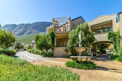 a building with a fountain in front of it at L'Ermitage Chateau and Villas at Villa 80 in Franschhoek