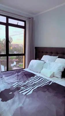 a bedroom with a large bed with a window at De Groove Luxury Homes in Cape Town