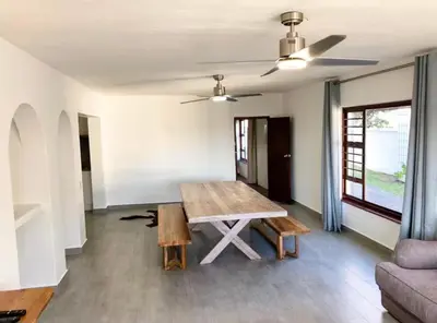 a living room with a table and a couch at Pura Vida Hermanus in Hermanus