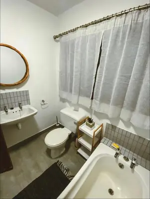 a bathroom with a toilet and a sink and a tub at Pura Vida Hermanus in Hermanus