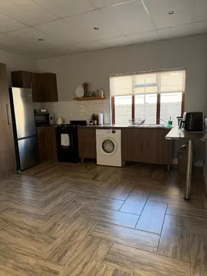 a kitchen with a refrigerator and a washing machine at Fijnbos Strand in Strand
