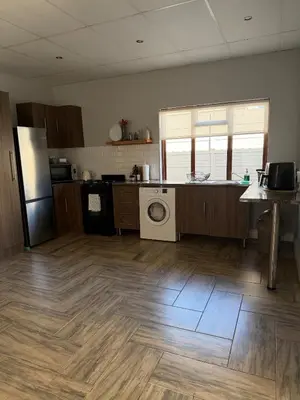 a kitchen with a refrigerator and a washer and dryer at Fijnbos Strand in Strand