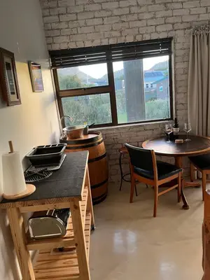 a room with a barrel and a table and chairs at BEACH FRONT Side Studio, 50 steps to main beach in Pringle Bay