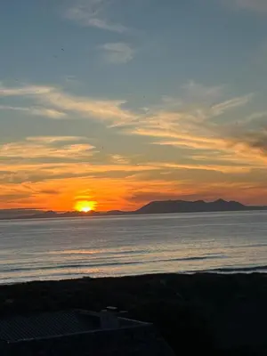 a sunset over the ocean with the sun in the sky at BEACH FRONT Side Studio, 50 steps to main beach in Pringle Bay