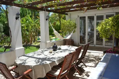 a dining table and chairs on a patio at Cape Dutch Family Home in the Winelands in Somerset West