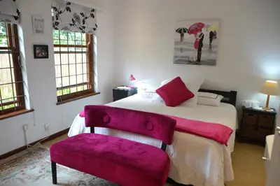 a bedroom with a bed and a purple chair at Cape Dutch Family Home in the Winelands in Somerset West